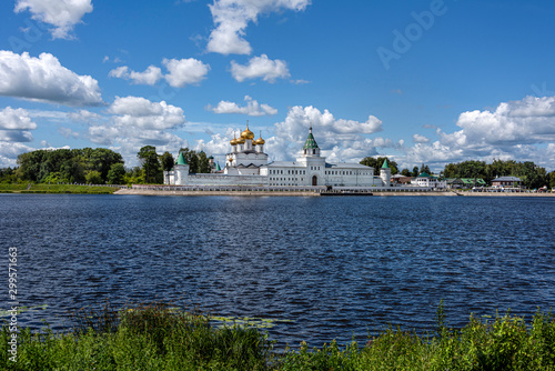 Russia, Golden Ring, Kostroma: Panorama of famous onion domed Ipatievsky Monastery seen from across the Kostroma River near the city center of the Russian town with blue cloudy sky - concept history