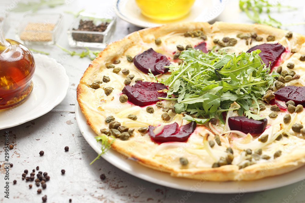 Pizza with mozzarella, caramelized beetroot, onion, capers and arugula. Pizza with mozzarella, caramelized beetroot, onion, capers and arugula.