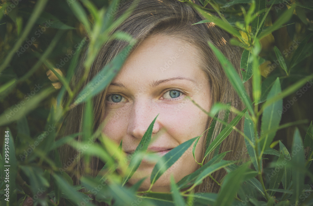 Portrait of woman on a background of thick green leaves of trees Portrait of woman on a background of thick green leaves of trees