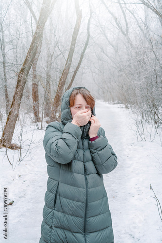 A woman froze walking in a snowy forest