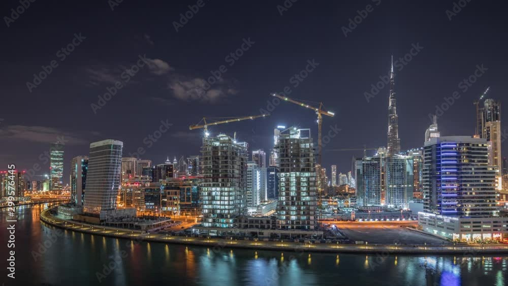 Skyline of the city at night with beautiful canal with reflections and bright skyscrapers aerial timelapse in Business Bay, Dubai, United Arab Emirates. Towers under construction Skyline of the city at night with beautiful canal with reflections and bright skyscrapers aerial timelapse in Business Bay, Dubai, United Arab Emirates. Towers under construction