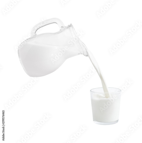Milk flowing from jug into glass. Dairy product isolated on white background