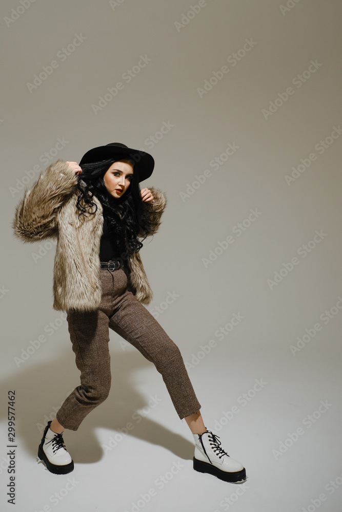 woman in a black hat is dancing in the studio. woman in a black hat is dancing in the studio.
