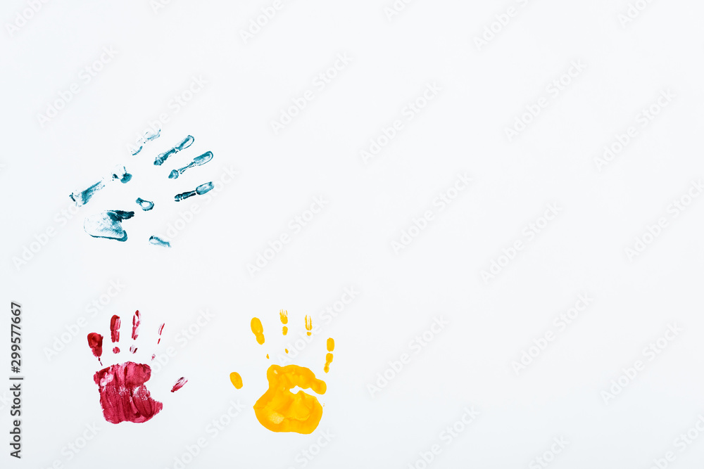 Fototapeta premium yellow, red and blue hand prints on white