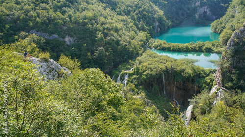 A visitor to the Plitvice Lakes Park admires the cascade of lakes and noisy waterfalls from a high cliff