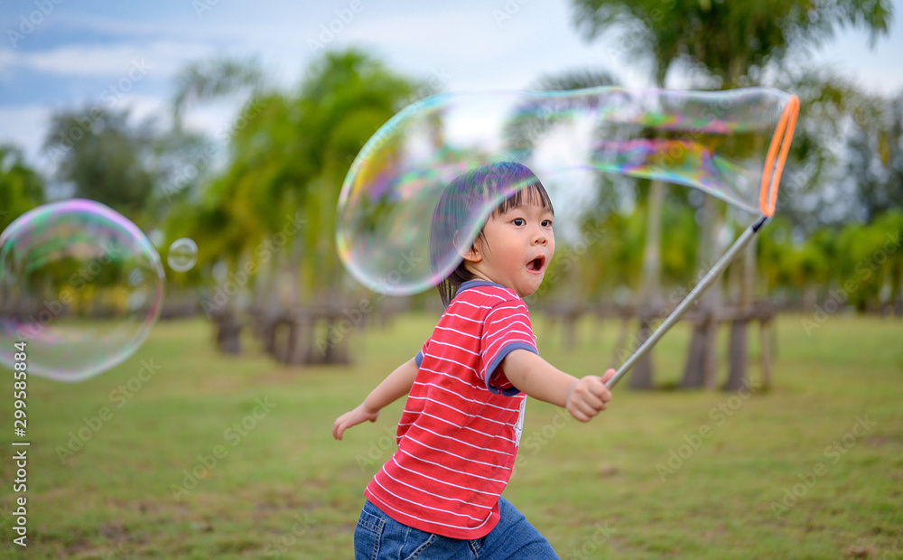 Cute Asian Kid making soap bubbles outside, summer time. Cute Asian Kid making soap bubbles outside, summer time.