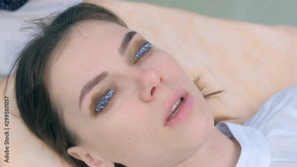 Woman with solution for lamination on lashes, lift eyelashes procedure in beauty salon, face closeup. Making lash lifting in cosmetology clinic. Woman with solution for lamination on lashes, lift eyelashes procedure in beauty salon, face closeup. Making lash lifting in cosmetology clinic.