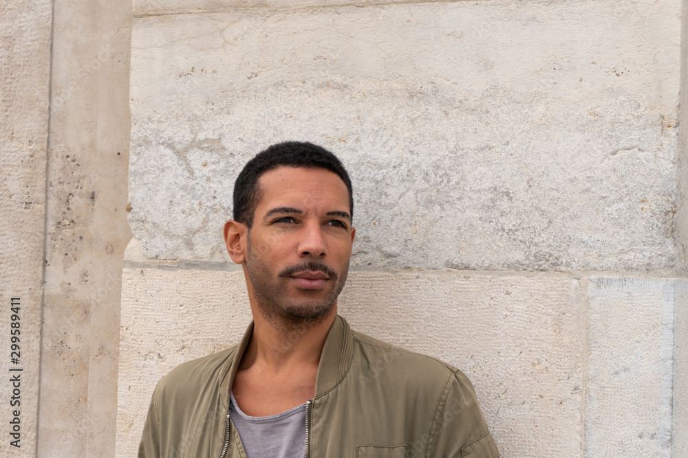 Obraz premium portrait of young man leaning against stone walll