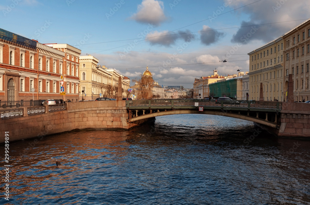 Fototapeta premium Krasnoflotsky bridge in the center of St. Petersburg on a cold autumn day, in the background St. Isaac's Cathedral