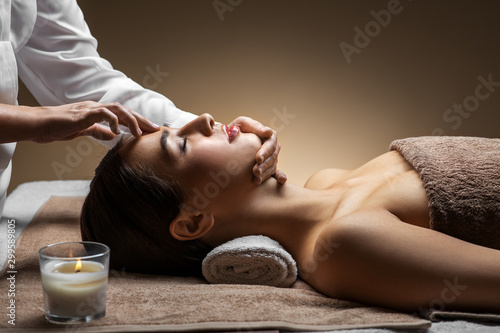 wellness, beauty and relaxation concept - beautiful young woman lying with cl...