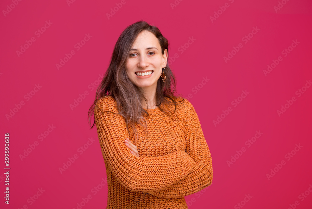 Young cheerful woman standing over pinky background with crossed arms and looking confident at the camera Young cheerful woman standing over pinky background with crossed arms and looking confident at the camera