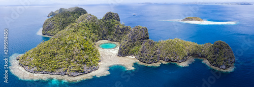 Highly eroded limestone islands rise from the beautiful, tropical seascape in Raja Ampat, Indonesia. This remote region is known for its extraordinary marine biodiversity.