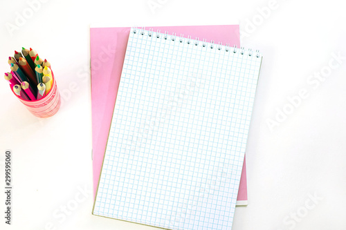 Pink notebook, opened notepad and pencils on a white background. Back to school, education concept, fashion office