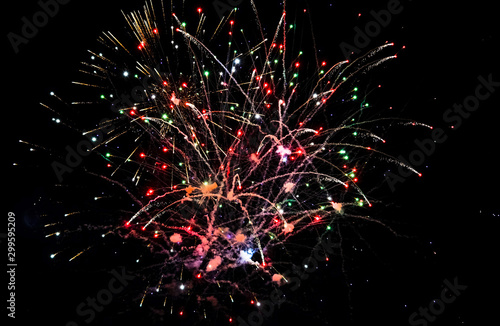 Colorful fireworks in the sky on black background. Festive colorful fireworks in the night sky.