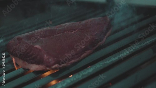 Delicious meat steaks cooking on the grill on fire