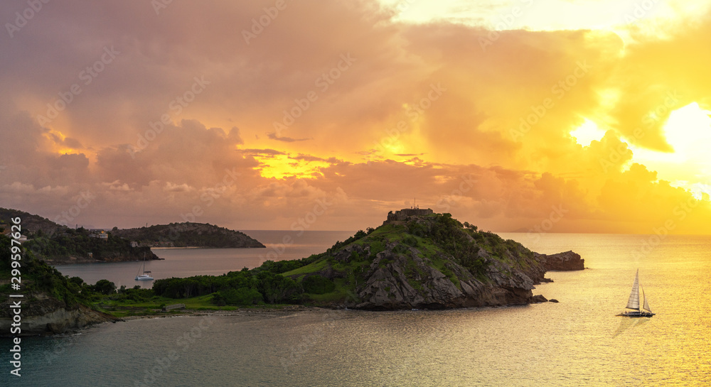 sailboat near Caribbean islands with sunset