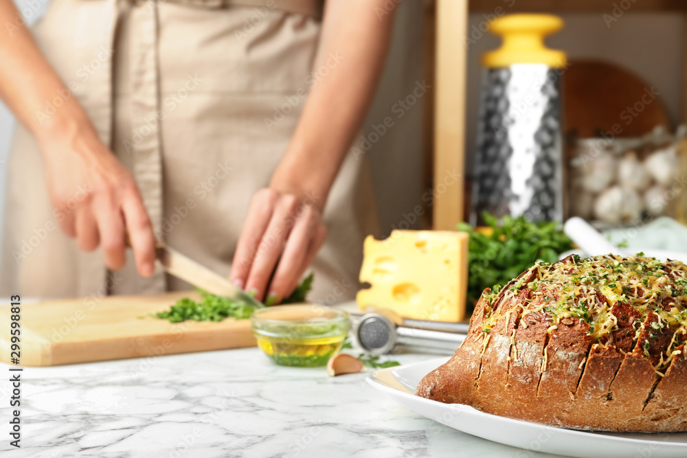 Tasty homemade garlic bread with cheese  and blurred woman on background. Space for text