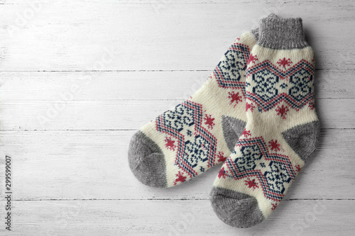 Knitted socks on white wooden background, flat lay