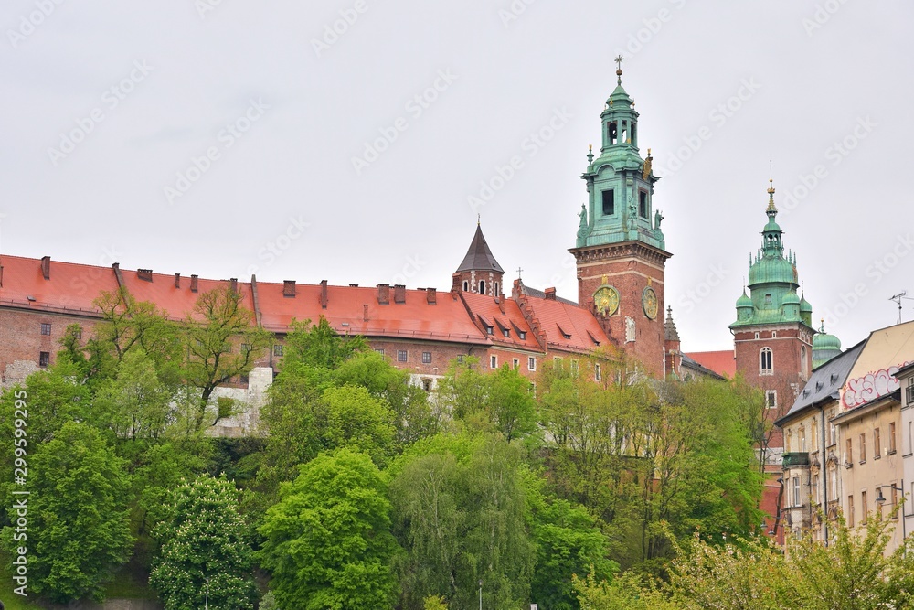 Obraz premium Krakow, Poland - May 2019. Historical building in the Krakow old town. View on famous tourist attraction in Krakow. Beautiful cityscape with Krakow landmarks in cloudy rainy day 