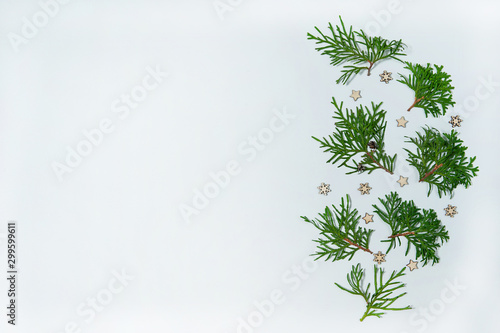 Christmas composition. The pattern is made of branches of evergreen thuja and decorative wooden snowflakes and stars on a white background. Christmas  winter  New year.