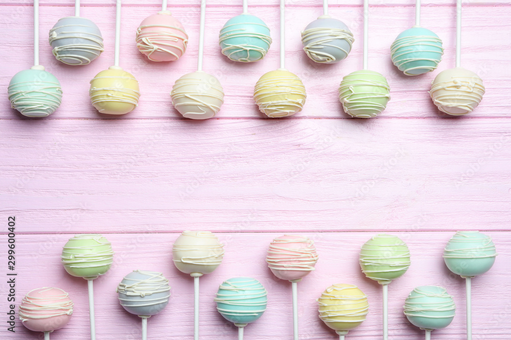 Frame made of sweet cake pops on pink wooden background, top view. Space for text Frame made of sweet cake pops on pink wooden background, top view. Space for text