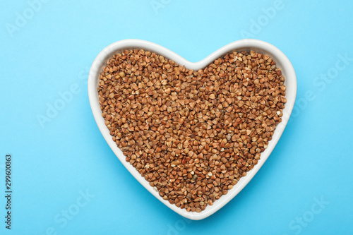 Buckwheat grains on light blue background, top view © New Africa