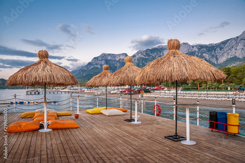 Photography Straw umbrellas and pillows on the seashore pier
