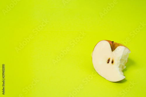 Bitten apple fruit sliced by half isolated in studio on a light green background