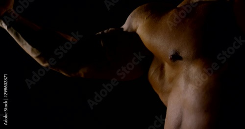 close-up of male body Builder on anabolic steroids and demonstration of muscles in a dark room photo