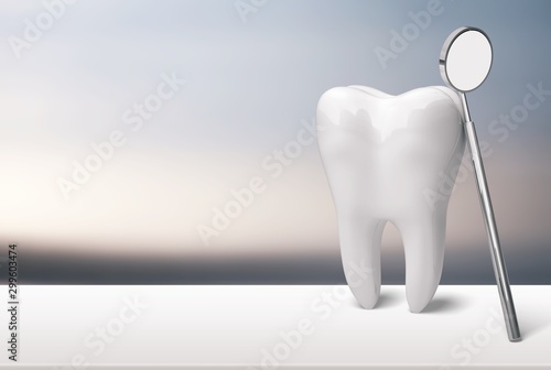 Tooth and dentist mirror on white table