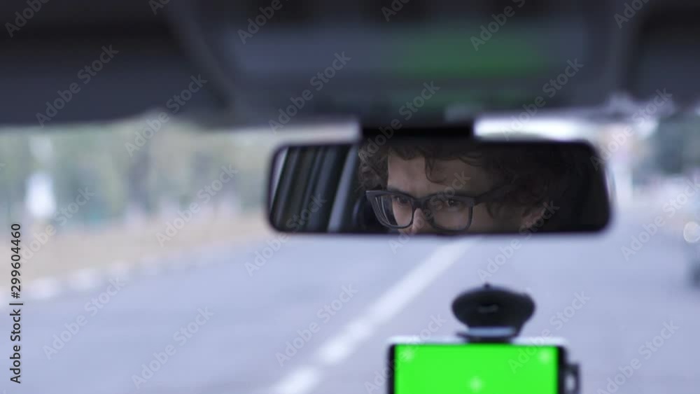 Driver driving in the reflection of a car mirror Driver driving in the reflection of a car mirror
