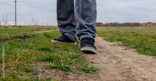 Close up shot of a man walking on dirt path