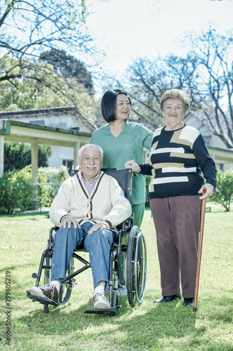 Female doctor reassuring elderly retired people in the hospital garden © jovannig