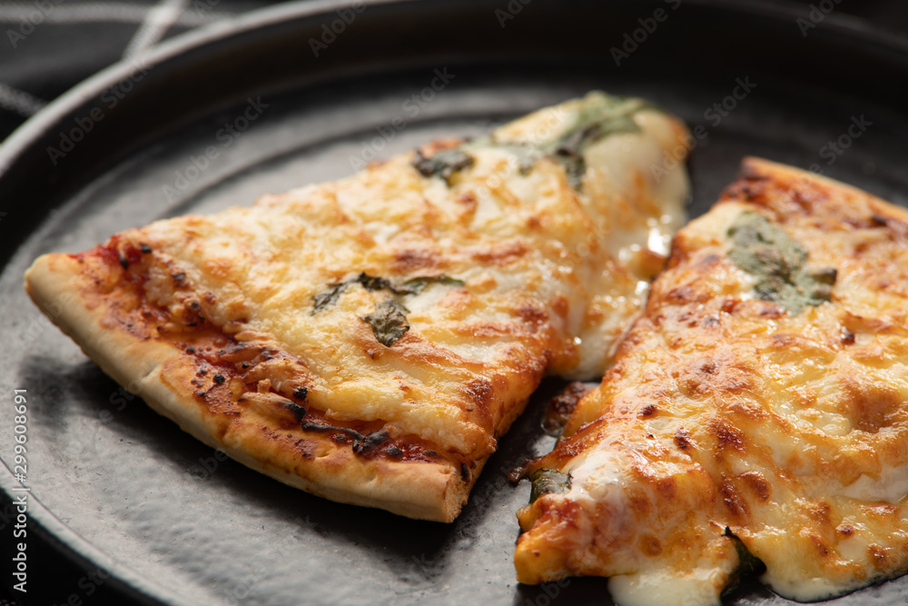 Pizza on a black background, on a plate with a drink Pizza on a black background, on a plate with a drink