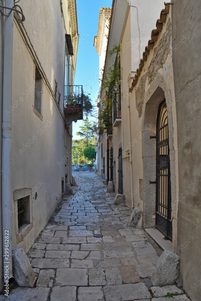Fototapeta Venosa, Italy, 10/27/2019. A narrow street among the old houses of a medieval village