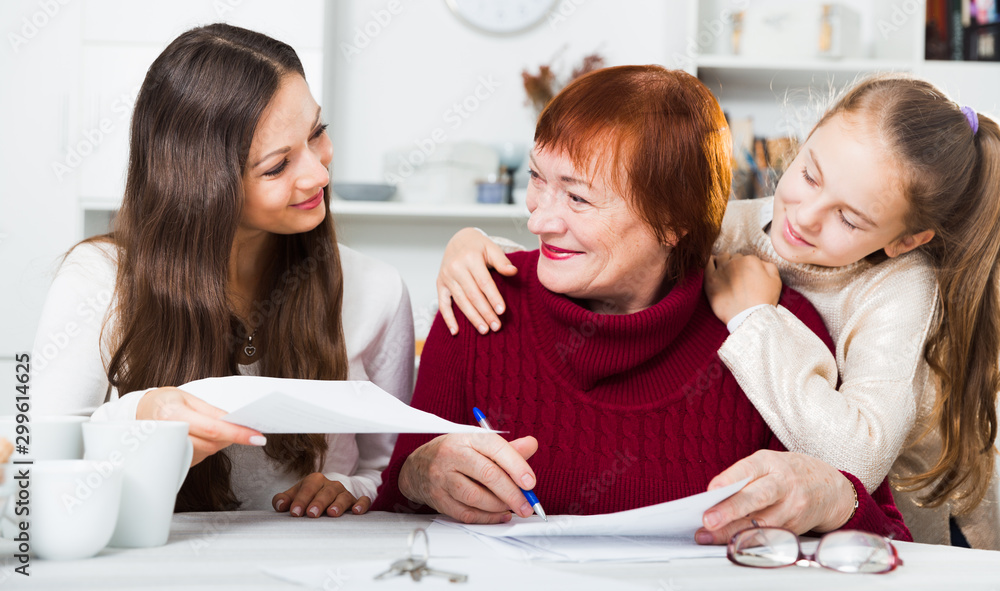 © JackF - Smiling senior woman with family writing papers