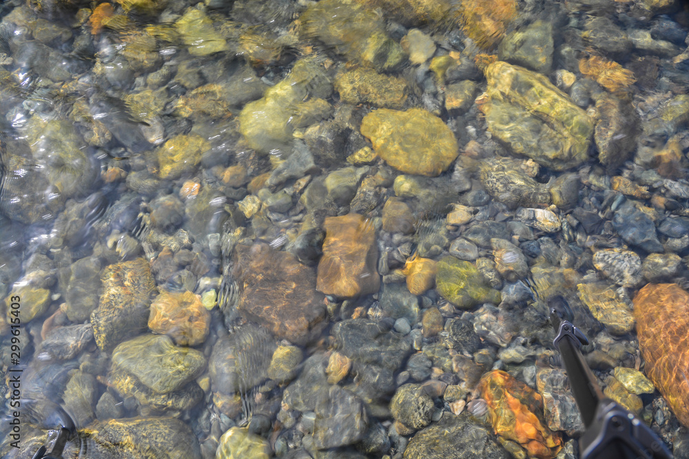 Background of shiny pebbles on the river bottom.