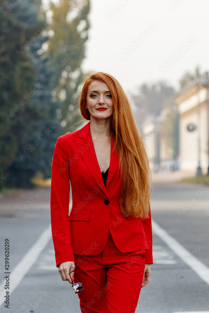 beautiful girl with red hair dressed in a red business suit. Business portrait. beautiful girl with red hair dressed in a red business suit. Business portrait.