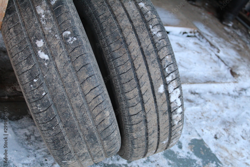 Obraz premium photo of old car wheels. they are round, standing against the wooden wall of the garage.summer tires removed from the car.on the rubber protector.