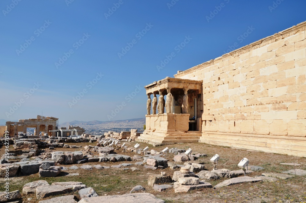 Athens, Greece, 10.28.2019. Ruins of Erechtheion (or Erechtheum) temple on a bright day in  Athenian Acropolis - world heritage site. Ancient Greek temple. Columns and statues of women.