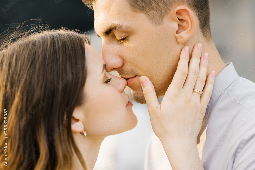 A man kisses his woman's nose, close-up kiss A man kisses his woman's nose, close-up kiss