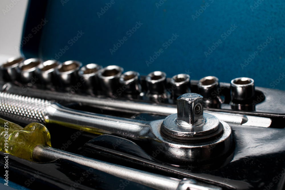 Closeup of a small socket set in a metal storage box with the sockets on the background. Closeup of a small socket set in a metal storage box with the sockets on the background.