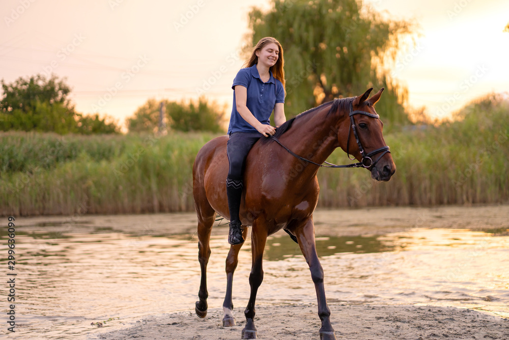 A young girl riding a horse on a shallow lake. A horse runs on water at sunset. Care and walk with the horse. Strength and Beauty A young girl riding a horse on a shallow lake. A horse runs on water at sunset. Care and walk with the horse. Strength and Beauty
