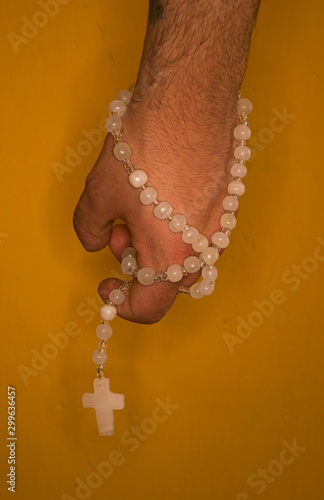 hand with a catholic rosary, necklace in one hand
