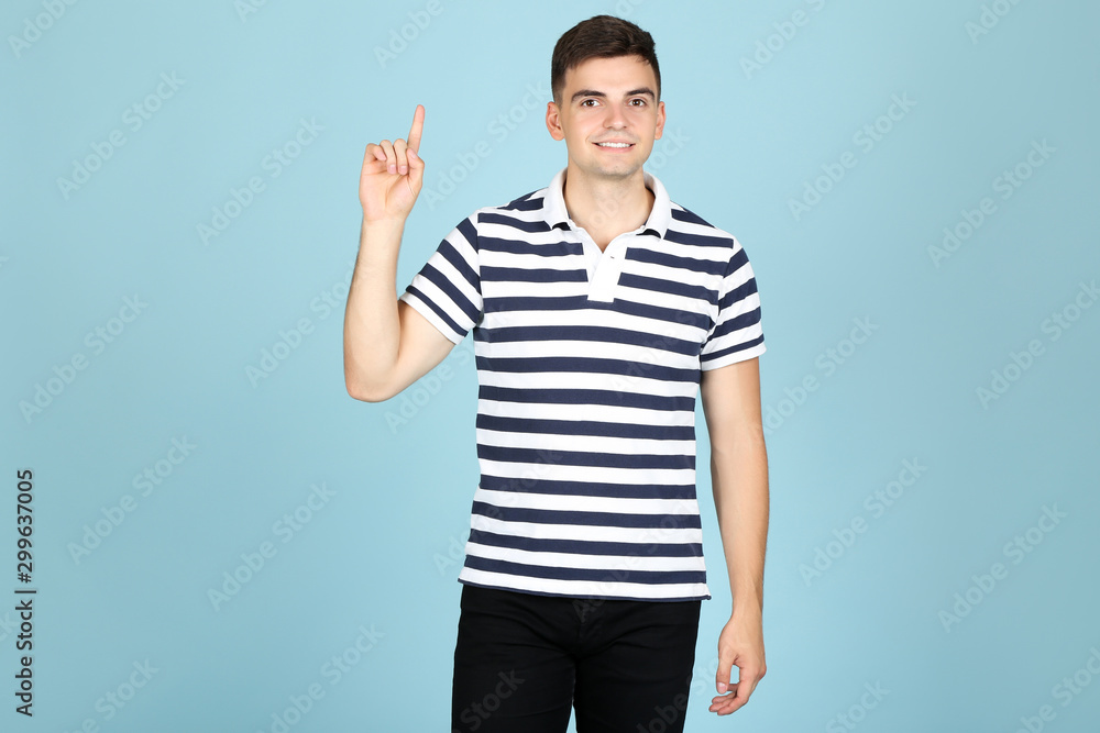 Young man showing finger up on blue background Young man showing finger up on blue background