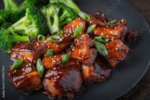 teriyaki chicken and broccoli on black plate