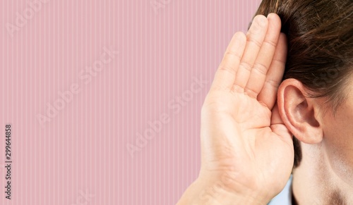 Woman ear listening concept on pink wall