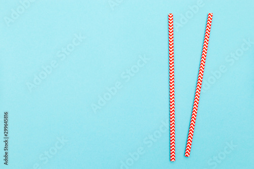 Fototapeta Naklejka Na Ścianę i Meble -  Two red straws for cocktail isolated on blue background. Copy space
