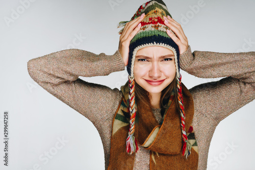 the girl capriciously with despair covered her ears with her hands. studio gray photo