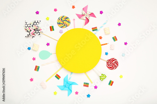 Colorful flat lay composition with various party items and candies on white background